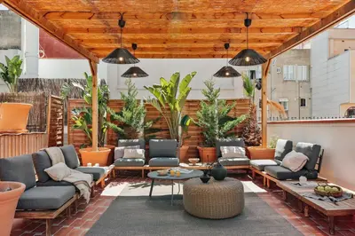 an outdoor patio with tables and chairs and potted plants at Oetune - 2 bedrooms and office in Gràcia in Barcelona