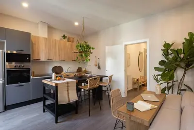 a kitchen and living room with a table and a couch at Damar - 2 bedrooms and balcony in Eixample Dreta in Barcelona