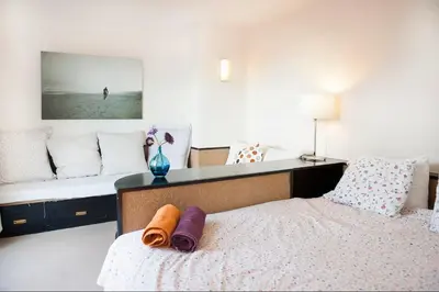 a bedroom with a bed and a bench with pillows at Attic with terrace Barcelona center in Barcelona