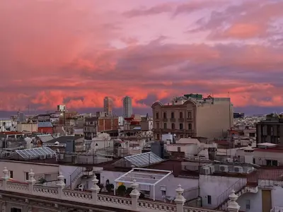 a view of a city with a sunset at Attic with terrace Barcelona center in Barcelona