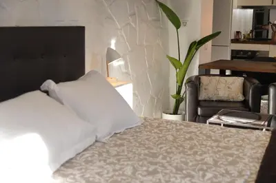 a bed with white pillows and a chair in a room at Barcelona Badalona Relax PLAYA y METRO in Badalona
