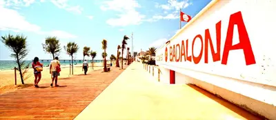a group of people walking on a boardwalk next to the beach at Barcelona Badalona Relax PLAYA y METRO in Badalona