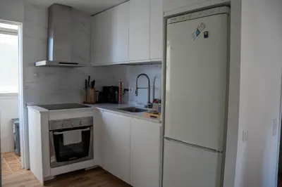 a kitchen with white cabinets and a refrigerator at Apartamento - Recinto Modernista in Barcelona
