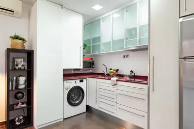 a kitchen with white cabinets and a washer and dryer at Balcón, WiFi y aire acondicionado en Plaza Cataluña in Barcelona