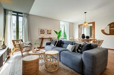 a living room with a blue couch and a tv at Sipura - 3 bedrooms and balcony in Eixample Dreta in Barcelona