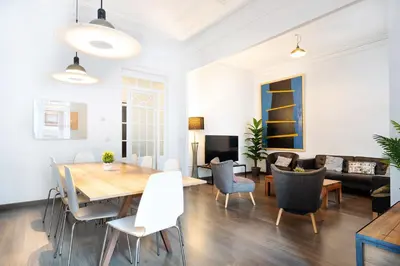 a dining room and living room with a table and chairs at Apartamento Premium 5 Hab con Balcón a Gran Vía - Grupos hasta 10 - Passeig Gràcia 7min in Barcelona