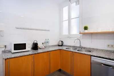a kitchen with a sink and a microwave at Apartamento Premium 5 Hab con Balcón a Gran Vía - Grupos hasta 10 - Passeig Gràcia 7min in Barcelona