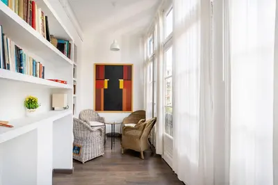 a hallway with chairs and a table and bookshelves at Apartamento Premium 5 Hab con Balcón a Gran Vía - Grupos hasta 10 - Passeig Gràcia 7min in Barcelona