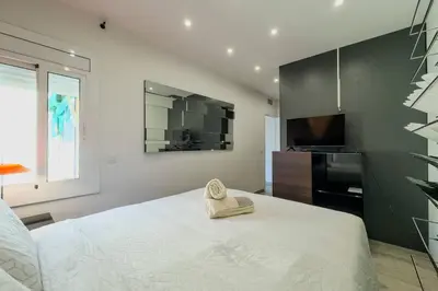 a bedroom with a white bed and a television at Comfort, Style & Value near Barceloneta Beaches in Barcelona