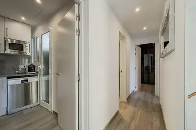 a kitchen with white walls and wooden floors at Comfort, Style & Value near Barceloneta Beaches in Barcelona