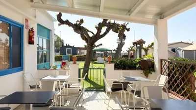 a tent with tables and benches in front of it at Camping Costa Dorada Tienda Lua in Canet de Mar
