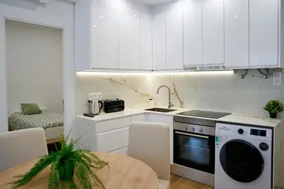 a kitchen with white cabinets and a sink and a dishwasher at Apartamentos Valentin in Barcelona