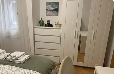 a bedroom with a bed and a dresser with a mirror at Alojamiento espacioso ideal para visitas en grupo in Terrassa