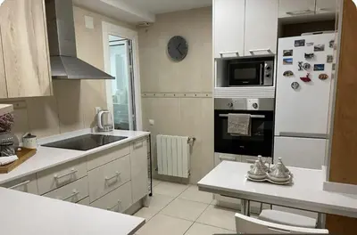 a kitchen with a white refrigerator and a sink at Alojamiento espacioso ideal para visitas en grupo in Terrassa
