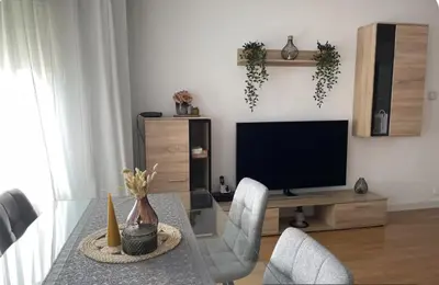 a living room with a table with chairs and a television at Alojamiento espacioso ideal para visitas en grupo in Terrassa