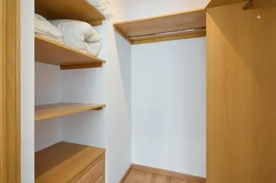 a bedroom with a closet with wooden shelves at 1IND1011 - One bedroom apartment in Barcelona