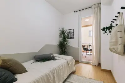 a bedroom with a bed in a room with a table at Agnello - 3 bedrooms and office in Sant Gervasi in Barcelona