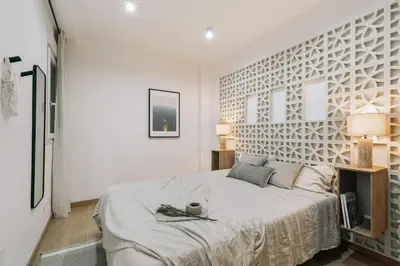 a bedroom with a large bed with a white wall at Agnello - 3 bedrooms and office in Sant Gervasi in Barcelona