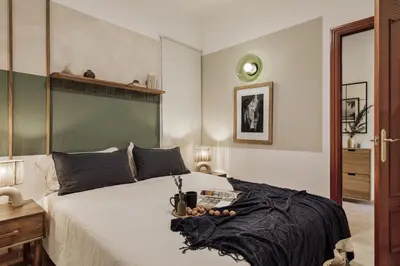 a bedroom with a large white bed with a green headboard at Nampi - 2 bedrooms and balcony in El Poblenou in Barcelona