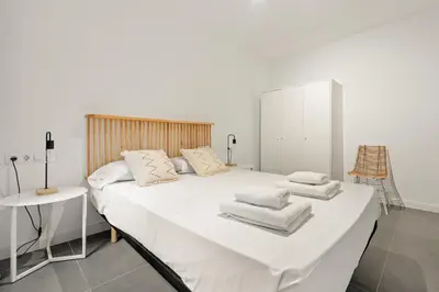 a white bed with white sheets and pillows on it at Flateli Espronceda 01 in Barcelona