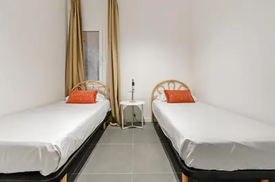 two twin beds in a room with a table at Flateli Espronceda 01 in Barcelona