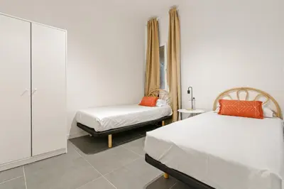 a bedroom with two beds and a cabinet at Flateli Espronceda 01 in Barcelona