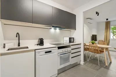 a kitchen with white appliances and a table with chairs at Flateli Espronceda 11 in Barcelona