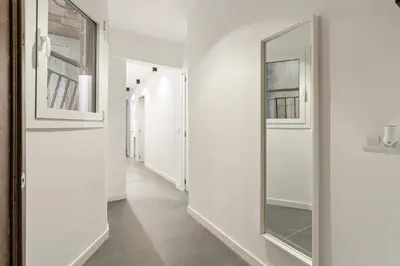 a hallway with a mirror and white walls at Flateli Espronceda 11 in Barcelona
