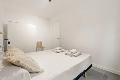 a white bedroom with a bed with white cabinets at Flateli Espronceda 11 in Barcelona