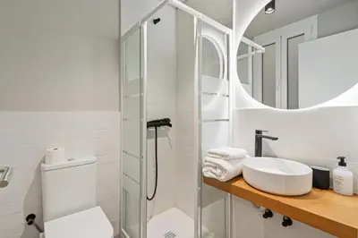 a white bathroom with a sink and a shower at Flateli Espronceda 22 in Barcelona