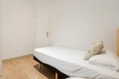 a bedroom with a bed with white sheets at Flateli Espronceda 32 in Barcelona