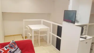 a living room with a small white table and a television at 016 DUPLEX centric in Barcelona