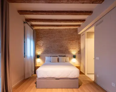 a bedroom with a bed and a brick wall at Casa Badajoz in Barcelona