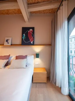 a living room with a couch and a kitchen at Casa Badajoz in Barcelona