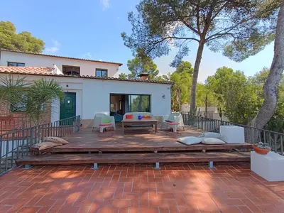 a patio with a table and chairs and a house at Sun & Sand Sanctuary - 2km to beach and 20km BCN! in Castelldefels