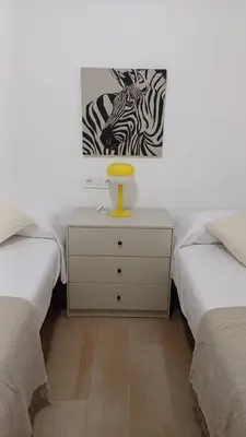 a bedroom with two beds and a dresser with a picture at Casa Vella de Casa Torrent in Canet de Mar