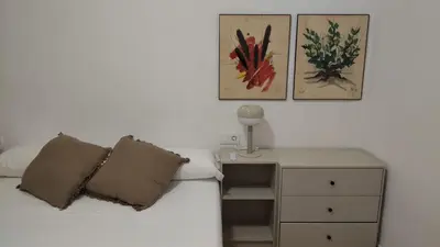 a bed with two pillows and a night stand with a lamp at Casa Vella de Casa Torrent in Canet de Mar