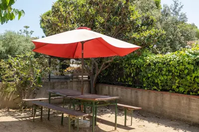 a picnic table with a red and white umbrella at Casa Vella de Casa Torrent in Canet de Mar