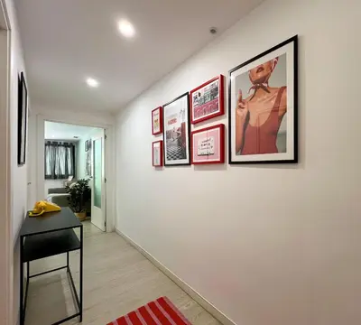 a hallway with framed pictures on a wall at Stay U-nique Apartment Roma in Barcelona