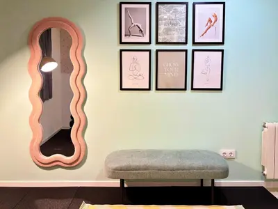 a room with a mirror and a bench and pictures at Stay U-nique Apartment Roma in Barcelona