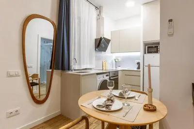 a small kitchen with a table and a mirror at Lodging Apartments Almirall Beach B1 in Barcelona