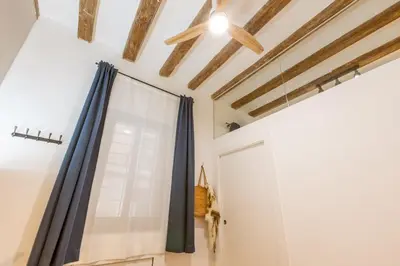 a room with a curtain and a door at Lodging Apartments Almirall Beach B1 in Barcelona
