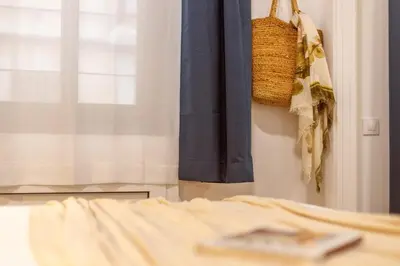 a bedroom with a bed and a window and a basket at Lodging Apartments Almirall Beach B1 in Barcelona