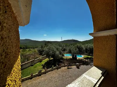 a view of a yard with a swimming pool and mountains at Maset del Garraf in Olesa de Bonesvalls