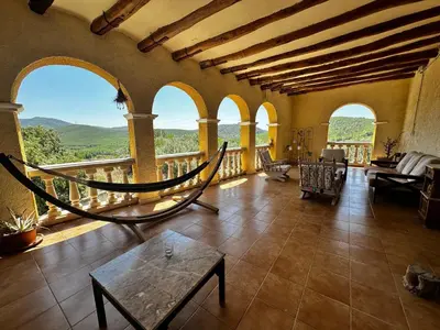 a living room with a balcony with a hammock at Maset del Garraf in Olesa de Bonesvalls