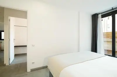 a white bedroom with a bed and a window at Stay U-nique Tapioles Central Apartment in Barcelona