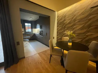 a dining room with a table and chairs and a kitchen at Apartamento de lujo a pie de metro in Terrassa