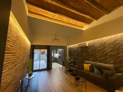 a living room with a couch and a brick wall at Apartamento de lujo a pie de metro in Terrassa
