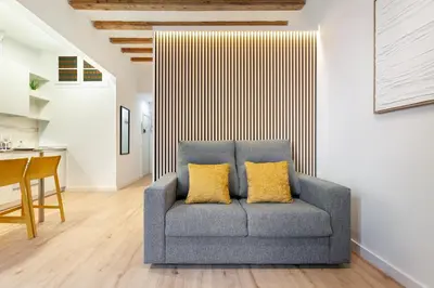 a gray couch with two yellow pillows in a living room at Art House Travessera de Gràcia-2 in Barcelona