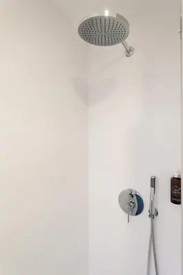 a shower head in a bathroom with a white wall at Art House Travessera de Gràcia-2 in Barcelona